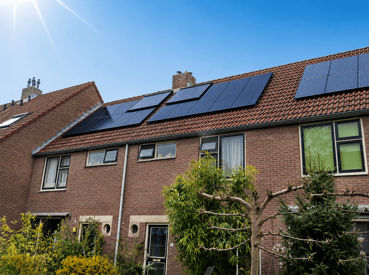 Witte woning met zonnecollectoren op het zuiddak